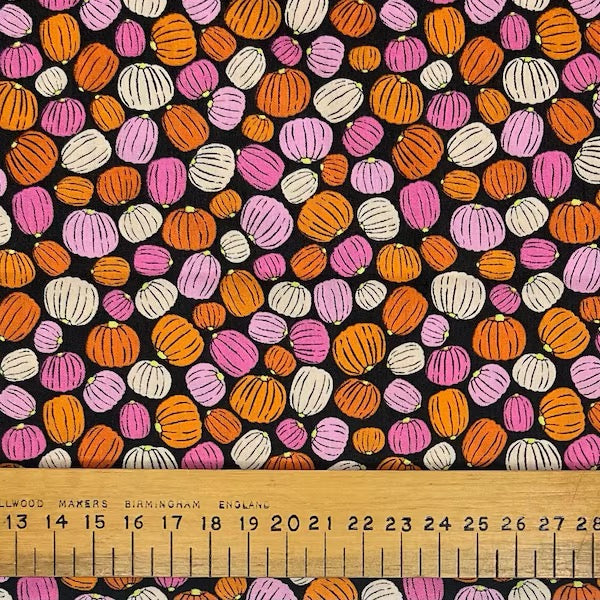 Multi coloured pumpkins on a black cotton