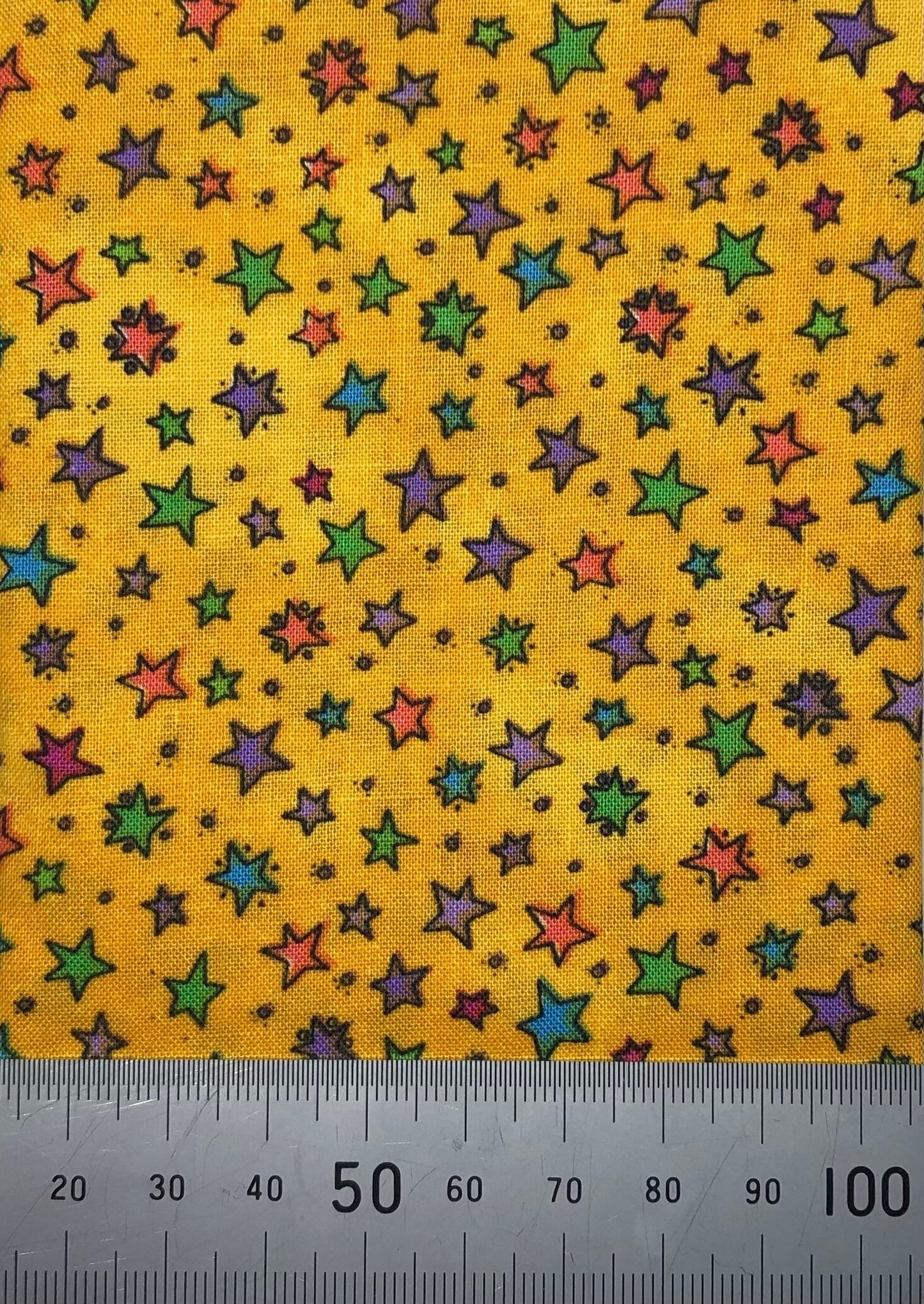 Multi coloured stars on a bright yellow cotton