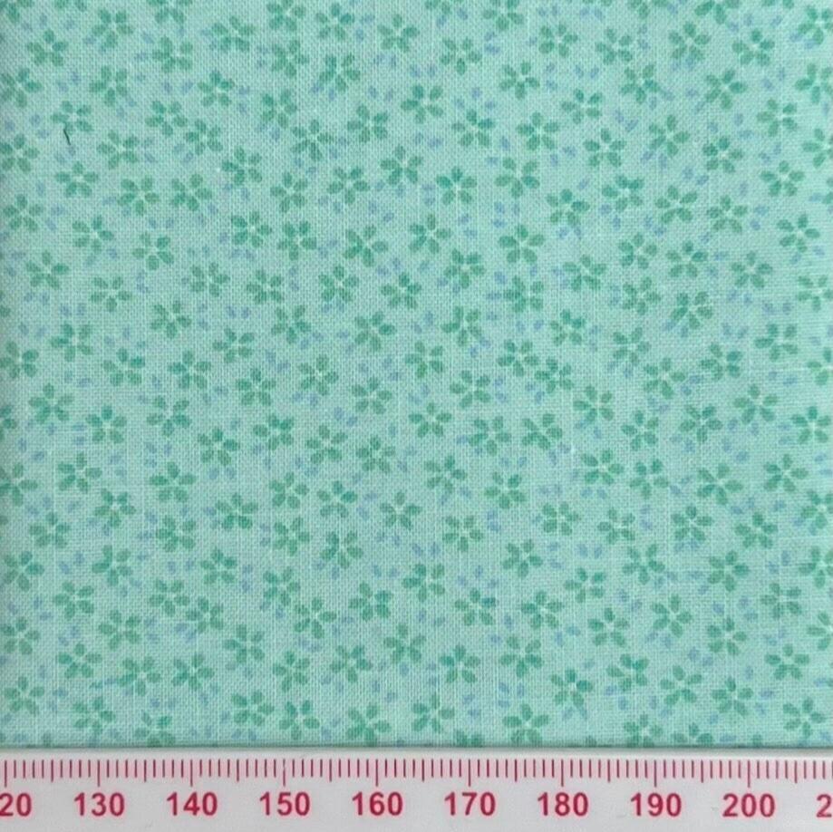 Tiny flowers on green cotton