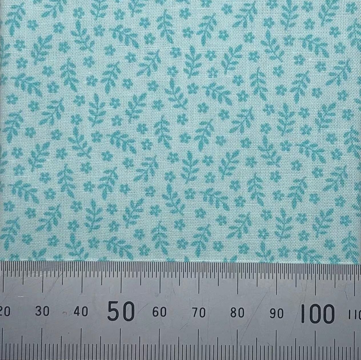 Leaves and flowers on a green cotton