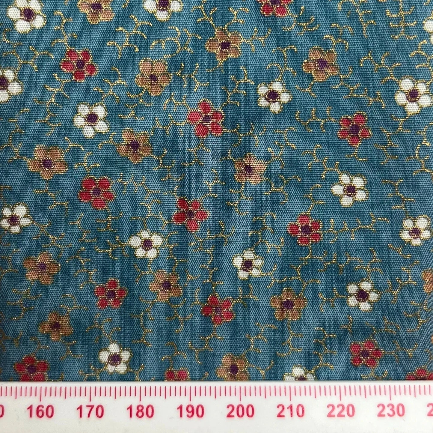 Red, white and gold flowers on blue cotton with metallic detailing