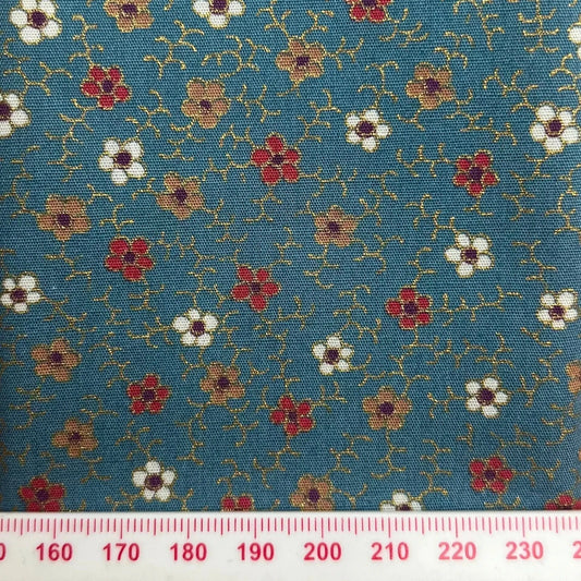 Red, white and gold flowers on blue cotton with metallic detailing