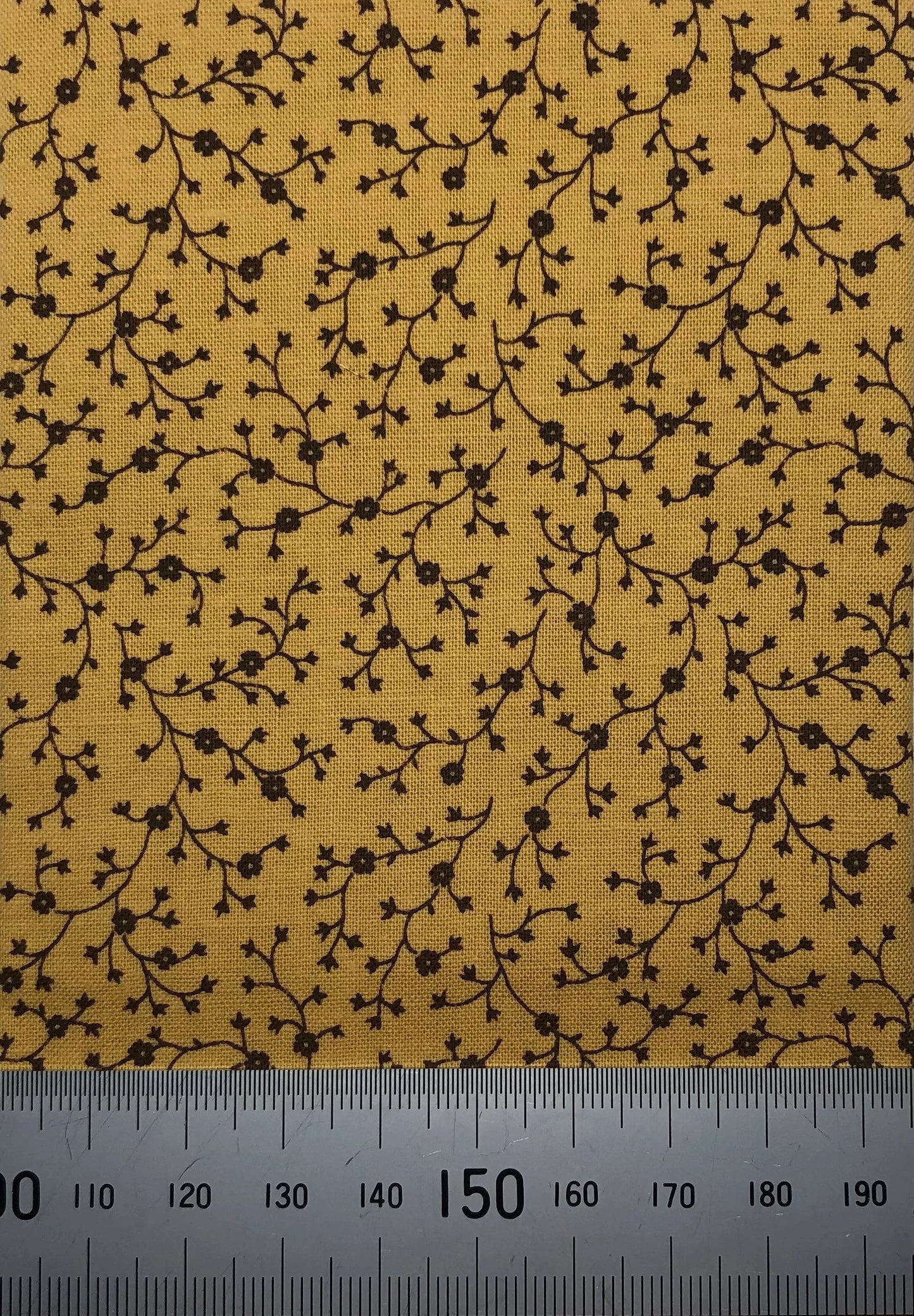 Brown floral branches on mustard cotton