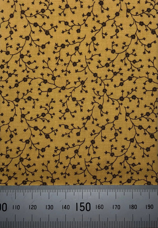 Brown floral branches on mustard cotton