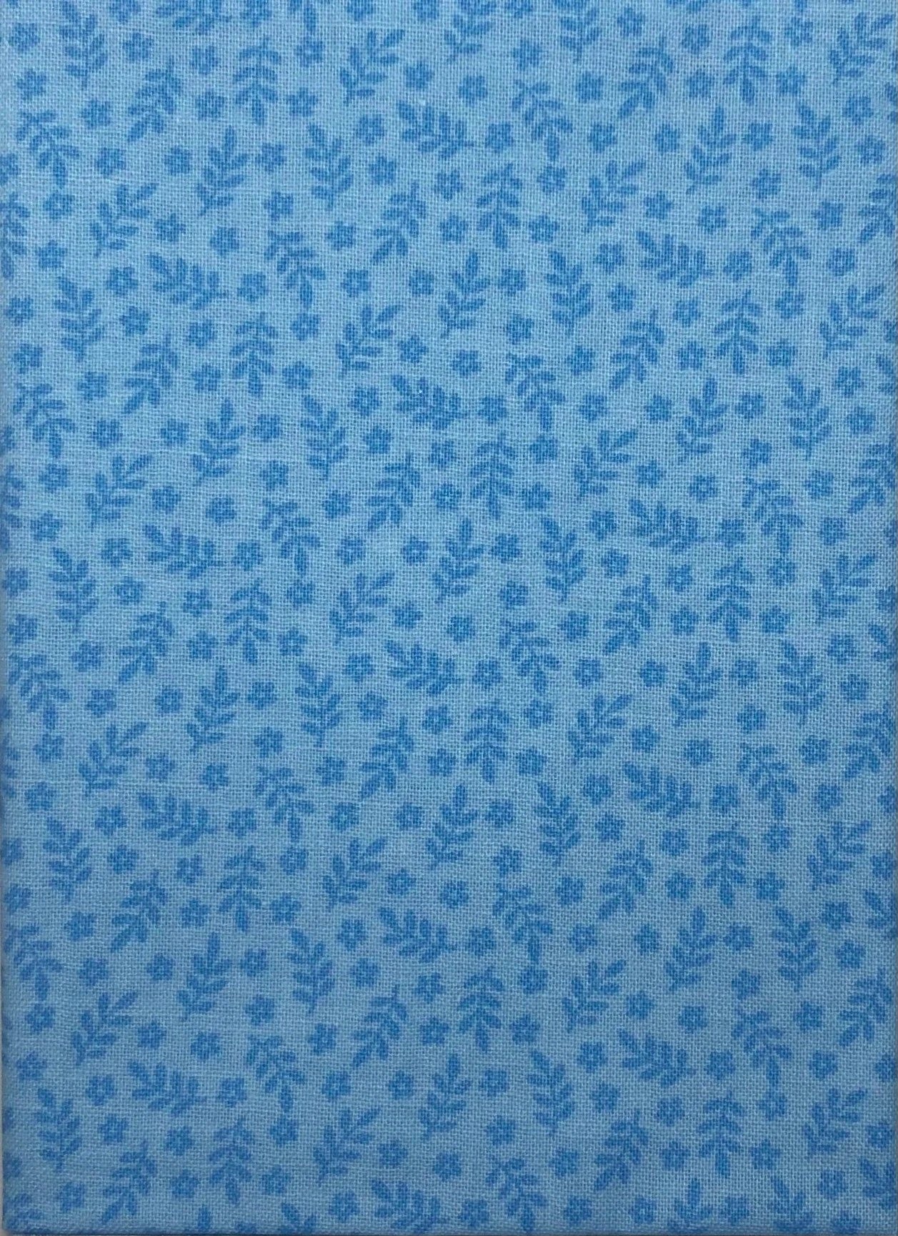 Leaves and flowers on a blue cotton